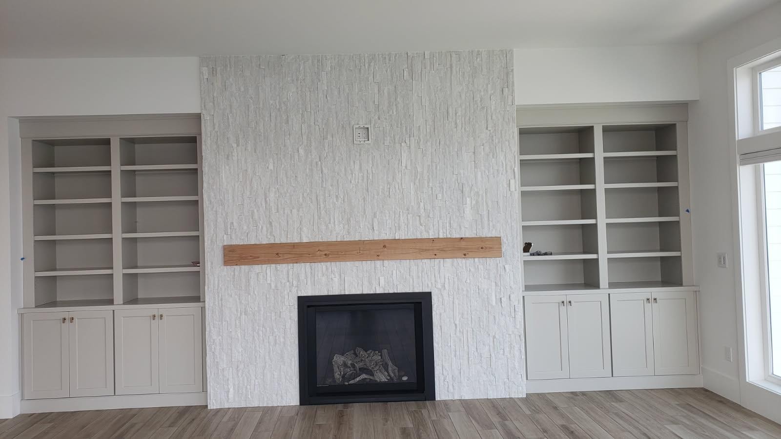 Stacked stone tile fireplace with built-in living area shelving in Wenatchee WA
