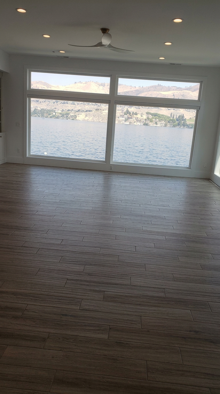 Wood-look tile flooring in a great room with lake view installed by River Rock Flooring